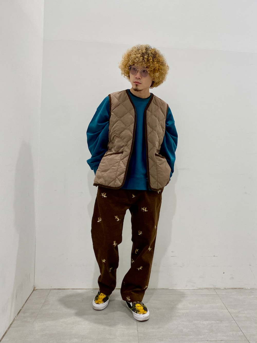 ブラック系のステンカラーコート、ベージュ系のブルゾン、グリーン系のスウェットを着用したメンズの冬コーディネートの2枚目の写真