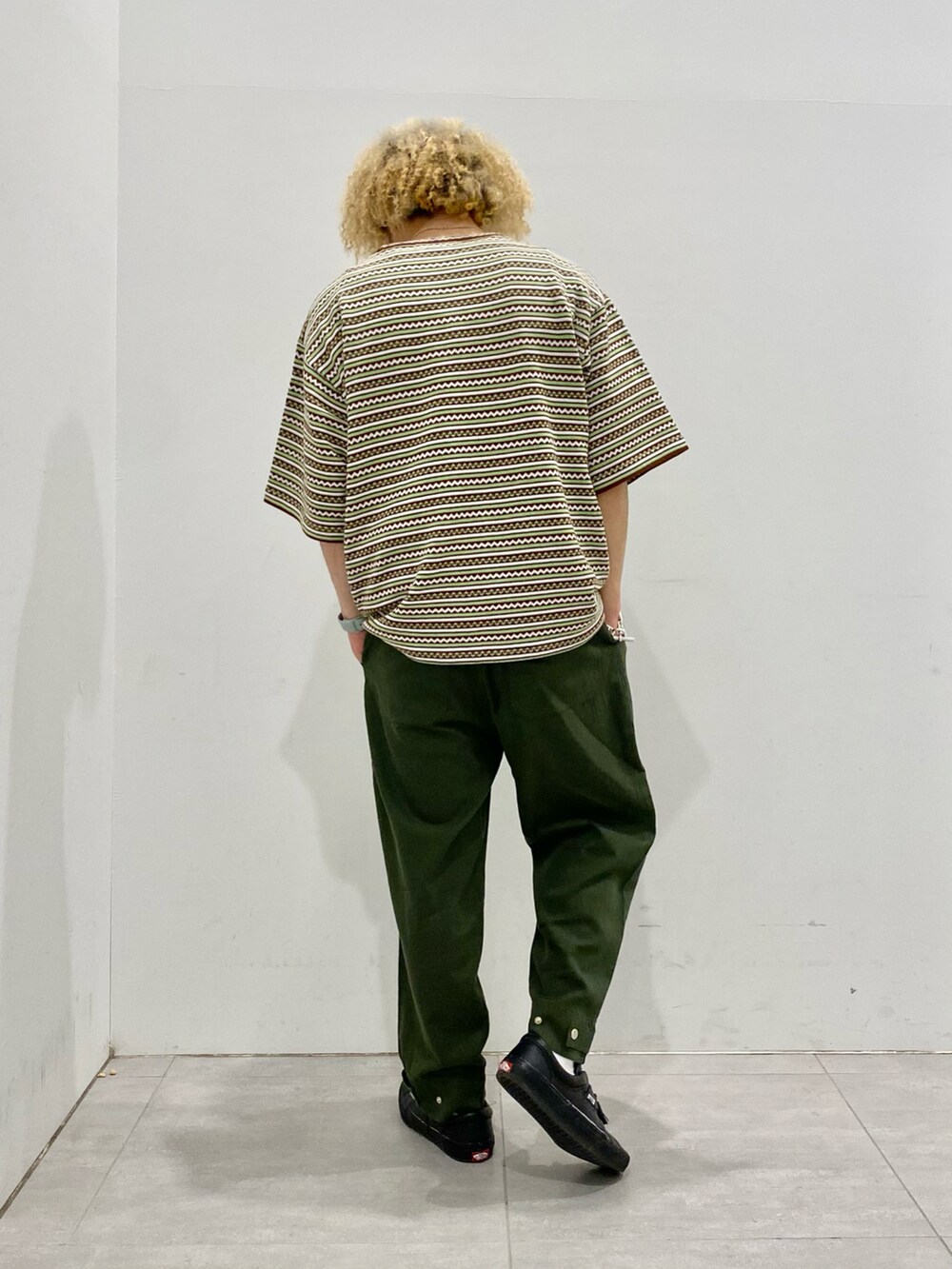 ブラウン系のTシャツ/カットソー、グリーン系のパンツを着用したメンズの春コーディネートの3枚目の写真