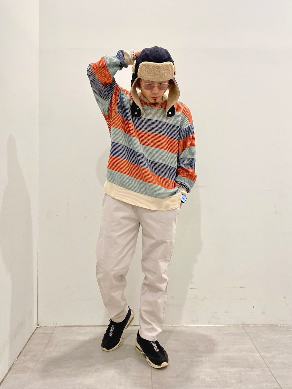 ブラック系のダウンジャケット/コート、ホワイト系のニット/セーター、グレー系のその他パンツを着用したメンズの冬コーディネートの2枚目の写真