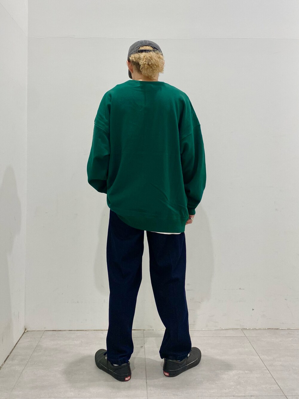 グリーン系のスウェット、ブルー系のデニムパンツを着用したメンズの秋コーディネートの3枚目の写真