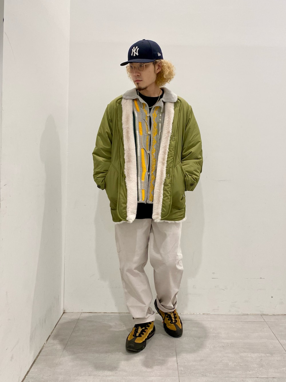 グリーン系のモッズコート、グレー系のカーディガン/ボレロ、ブラック系のTシャツ/カットソーを着用したメンズの冬コーディネートの2枚目の写真