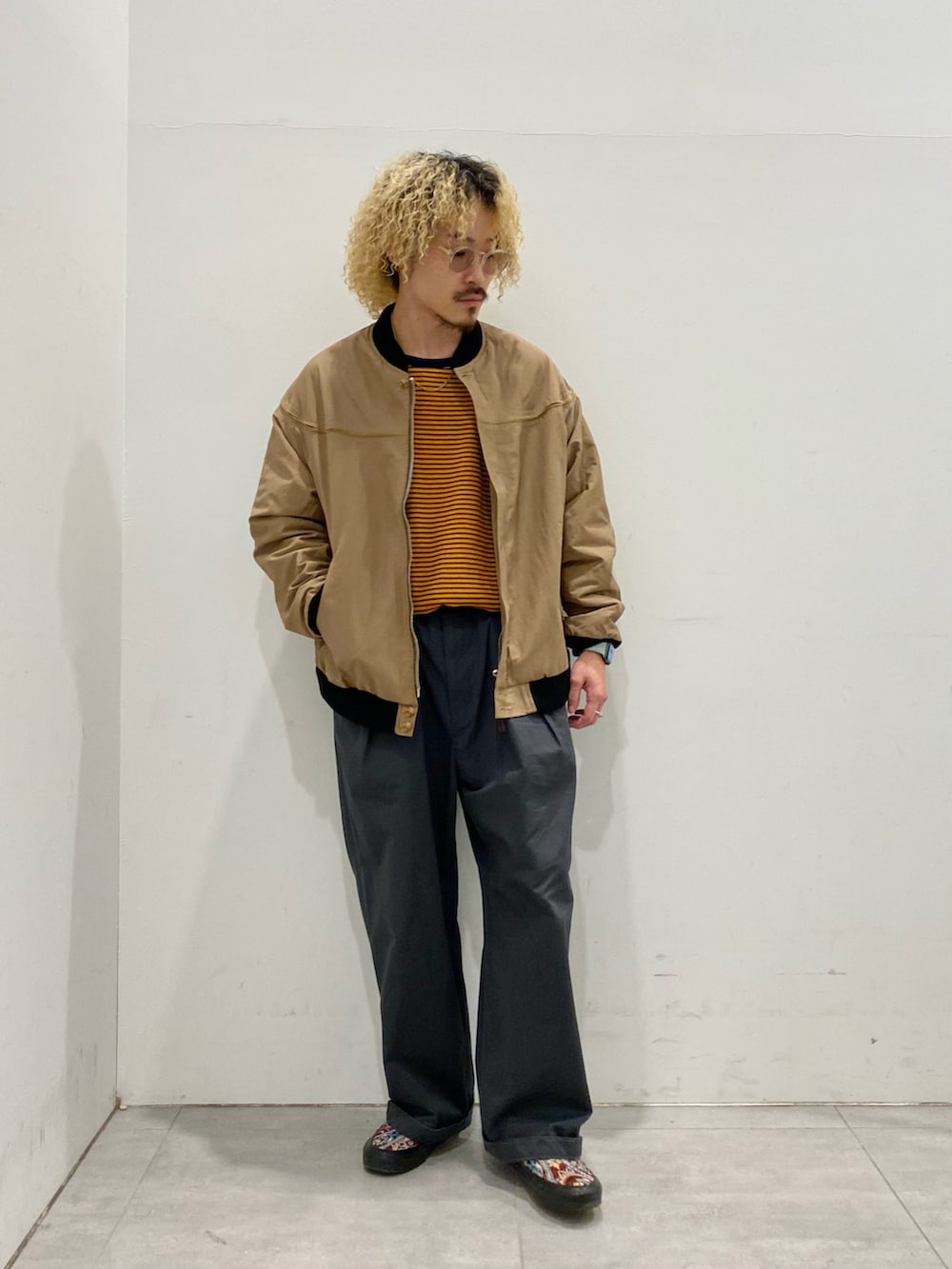 ベージュ系のブルゾン、オレンジ系のTシャツ/カットソーを着用したメンズの秋コーディネートの2枚目の写真