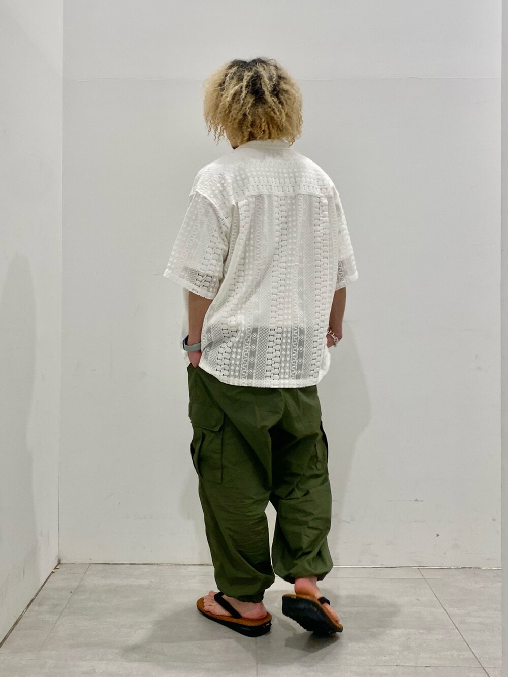 ホワイト系のシャツ/ブラウス、グリーン系のカーゴパンツ、ブラウン系のサンダルを着用したメンズの春コーディネートの3枚目の写真