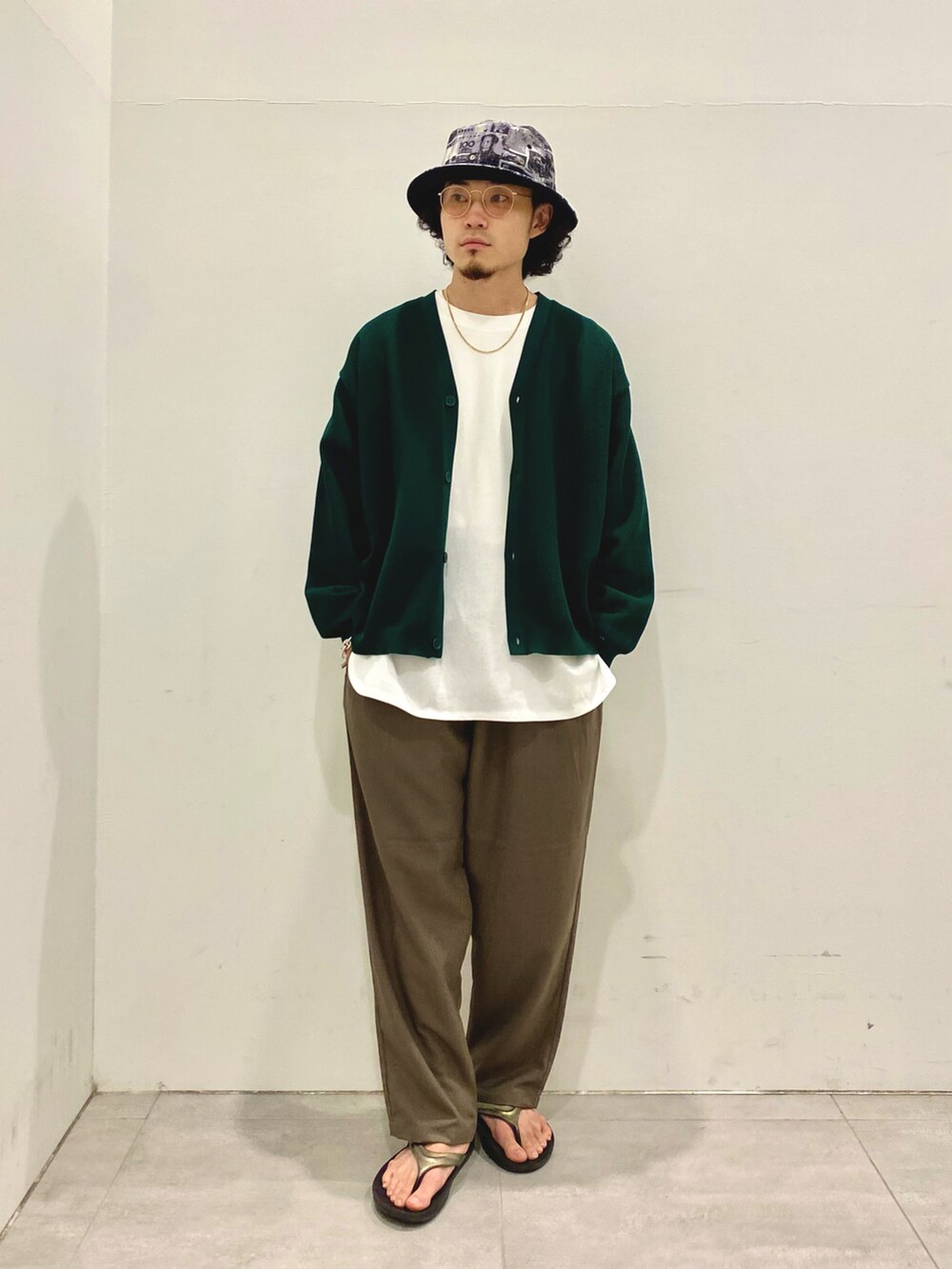 グリーン系のカーディガン/ボレロ、ブラウン系のスラックスを着用したメンズの夏コーディネートの2枚目の写真