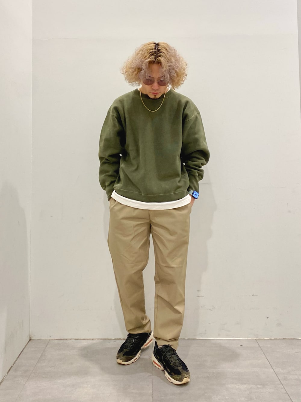 ブラック系のダウンジャケット/コート、グリーン系のスウェット、ベージュ系のチノパンツを着用したメンズの冬コーディネートの2枚目の写真