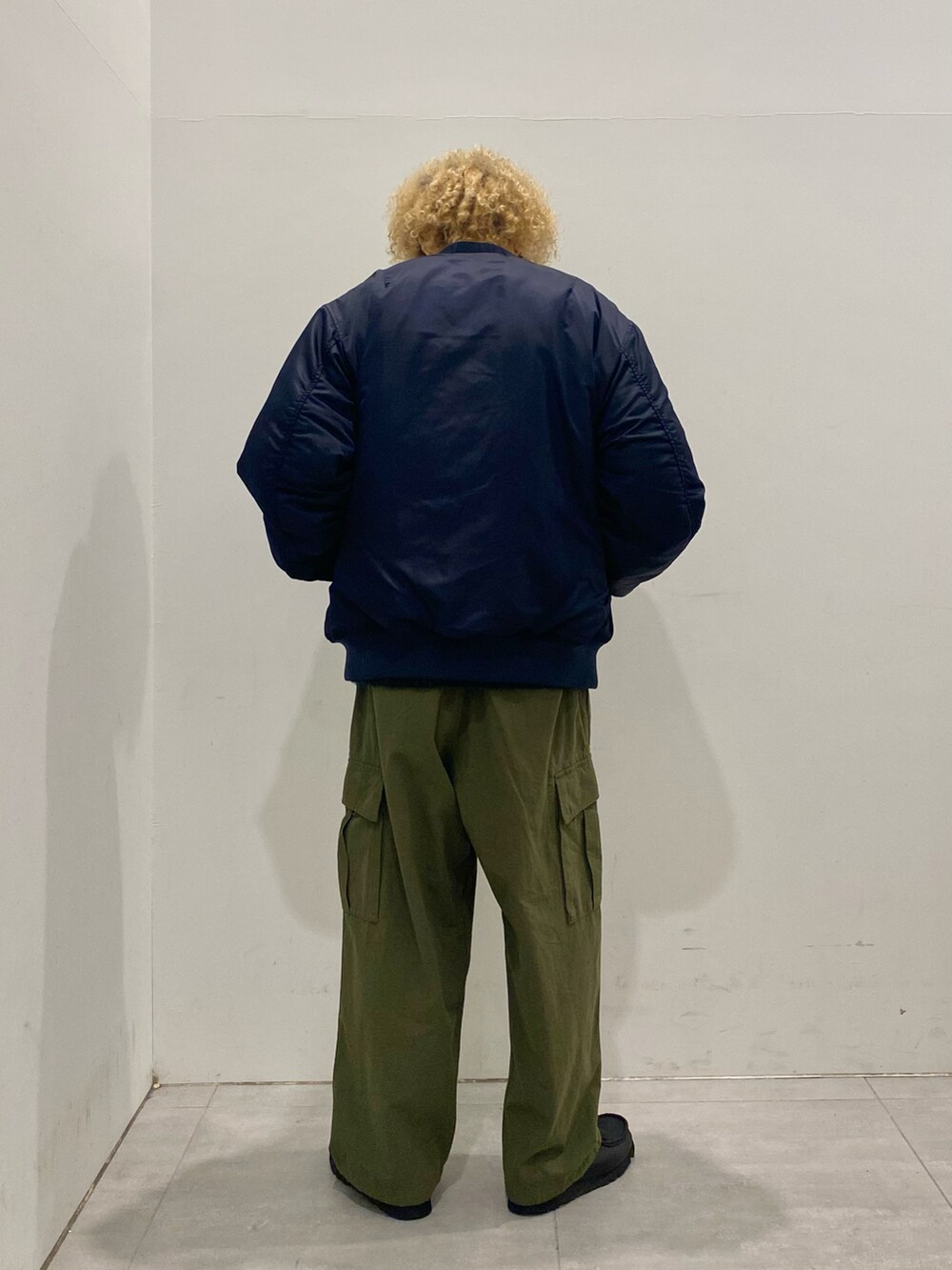 ブルー系のMA-1、ブルー系のニット/セーター、グリーン系のカーゴパンツを着用したメンズの秋コーディネートの2枚目の写真