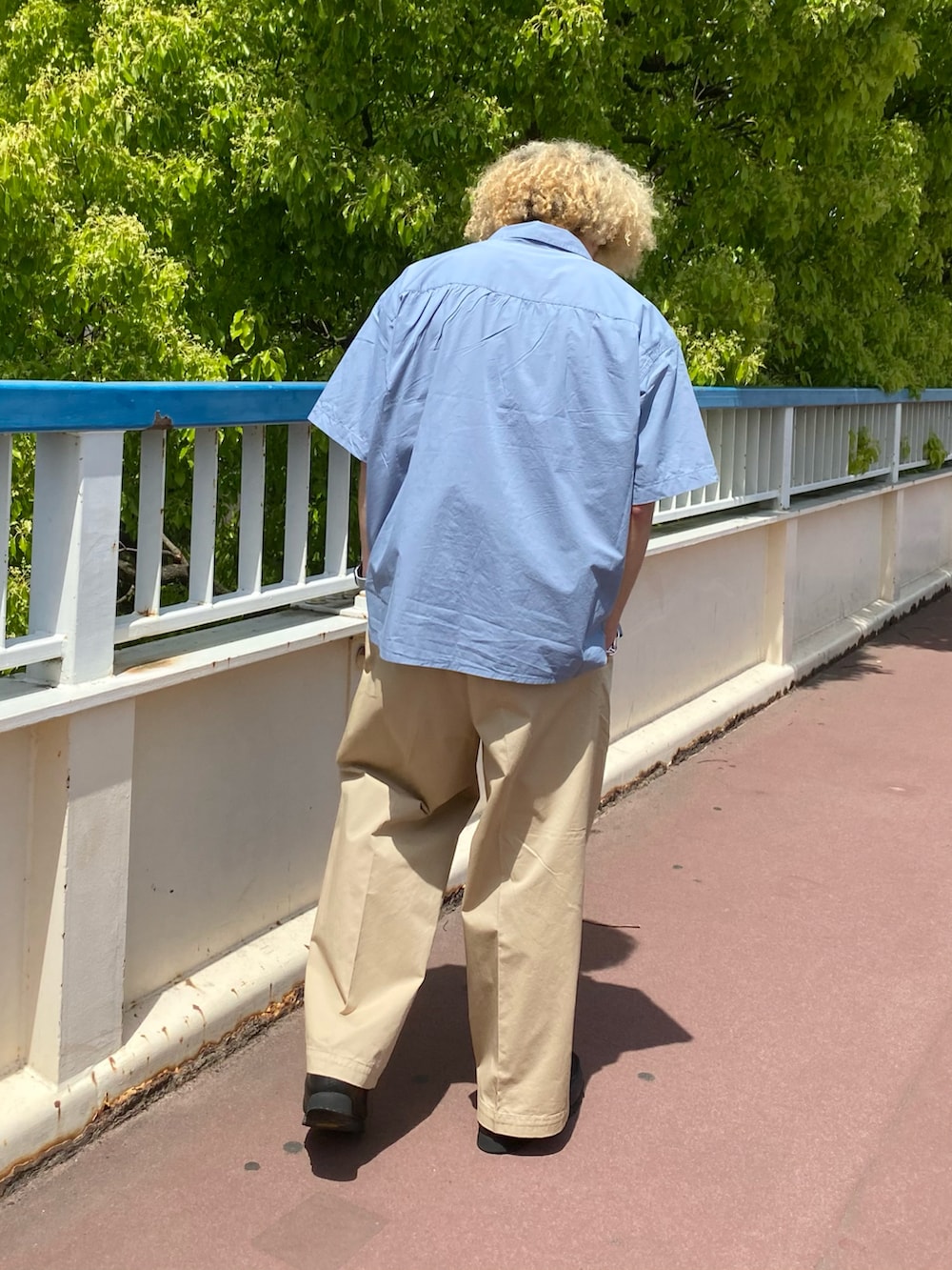 ブルー系のシャツ/ブラウス、ベージュ系のチノパンツを着用したメンズの夏コーディネートの3枚目の写真