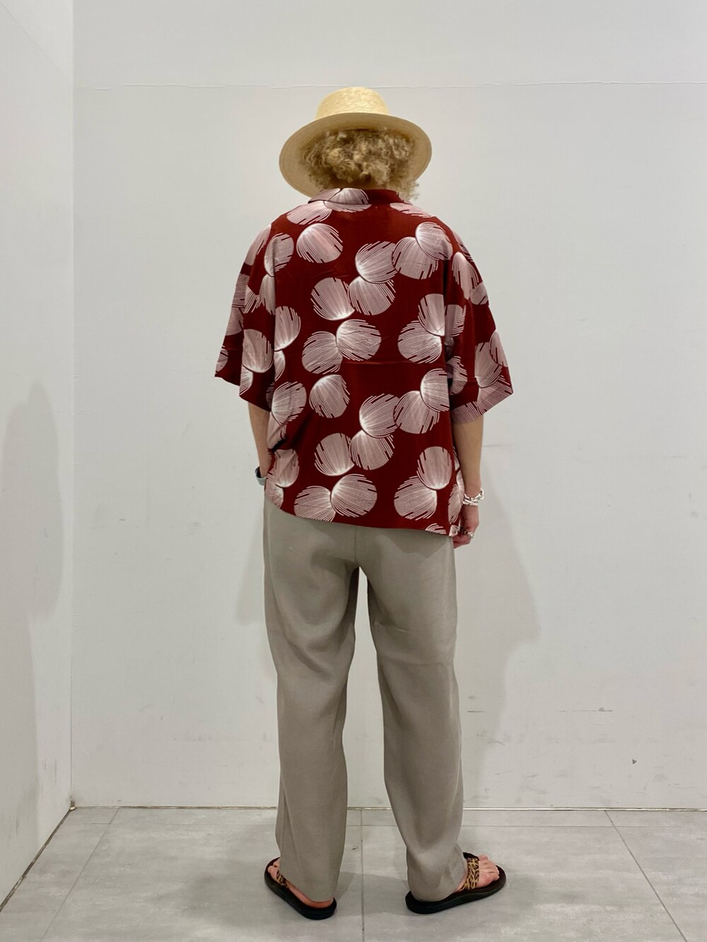 レッド系のシャツ/ブラウス、グレー系のスラックス、ホワイト系のハットを着用したメンズの夏コーディネートの3枚目の写真