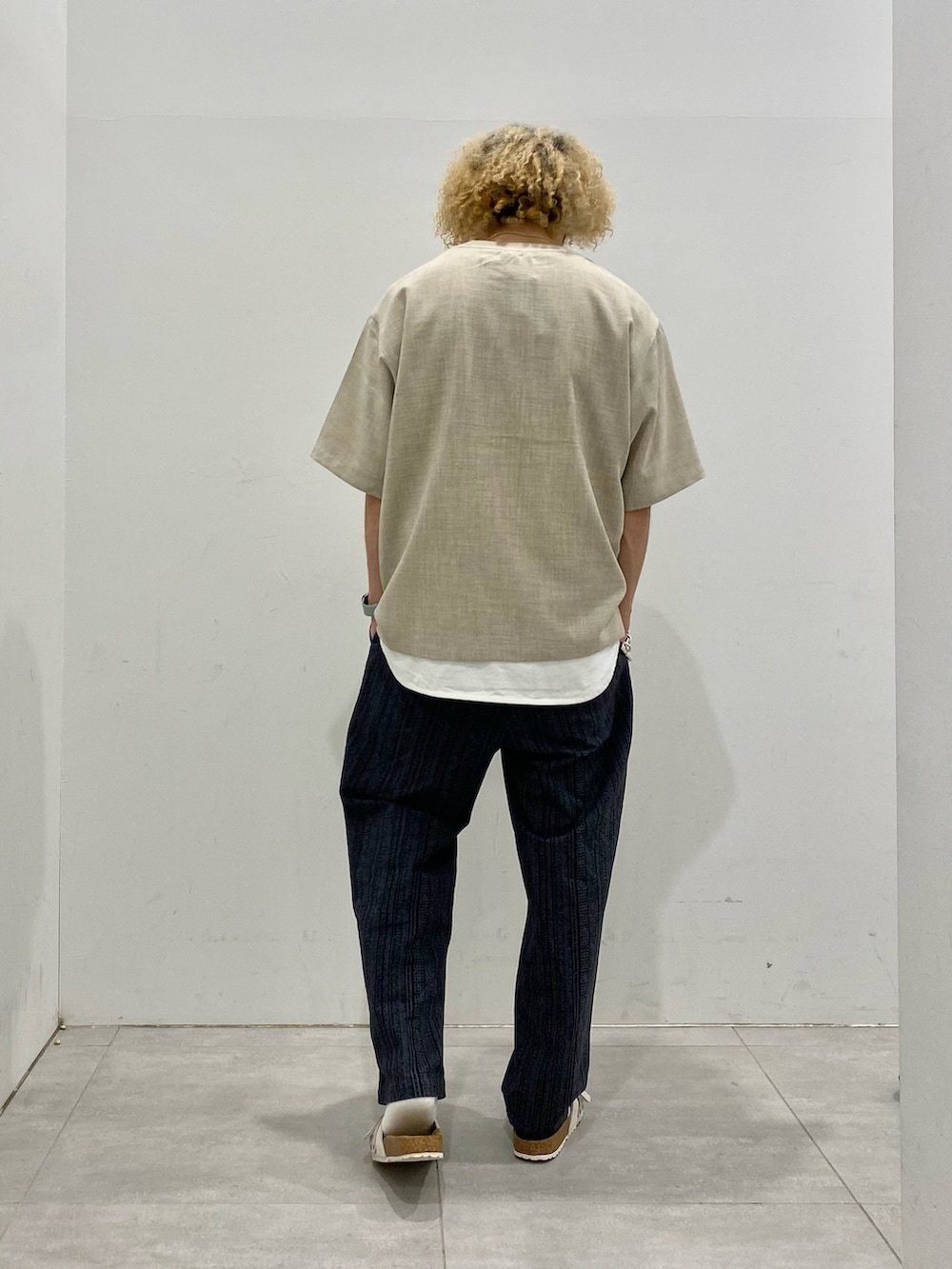 ホワイト系のTシャツ/カットソー、ブラック系のその他パンツ、ホワイト系のサンダルを着用したメンズの夏コーディネートの3枚目の写真