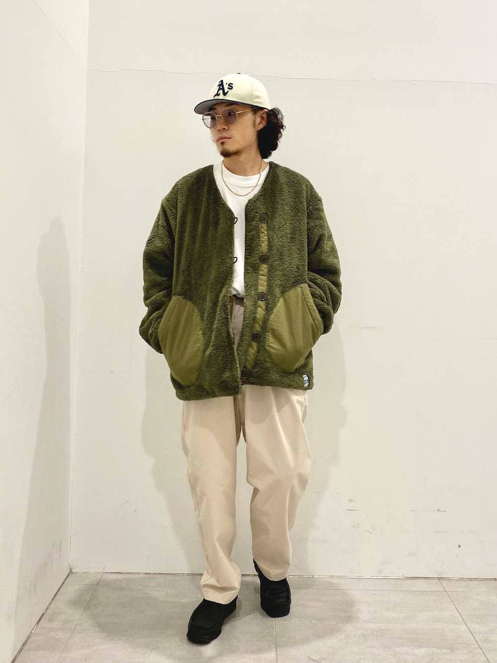 グリーン系のミリタリージャケット、ベージュ系のその他パンツを着用したメンズの秋コーディネートの2枚目の写真