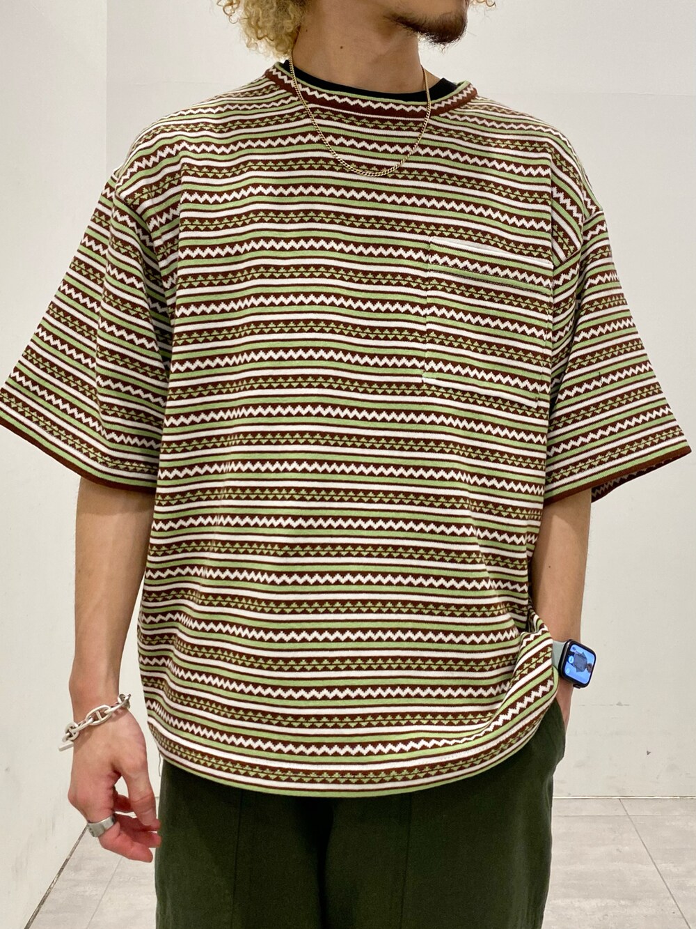 ブラウン系のTシャツ/カットソー、グリーン系のパンツを着用したメンズの春コーディネートの4枚目の写真