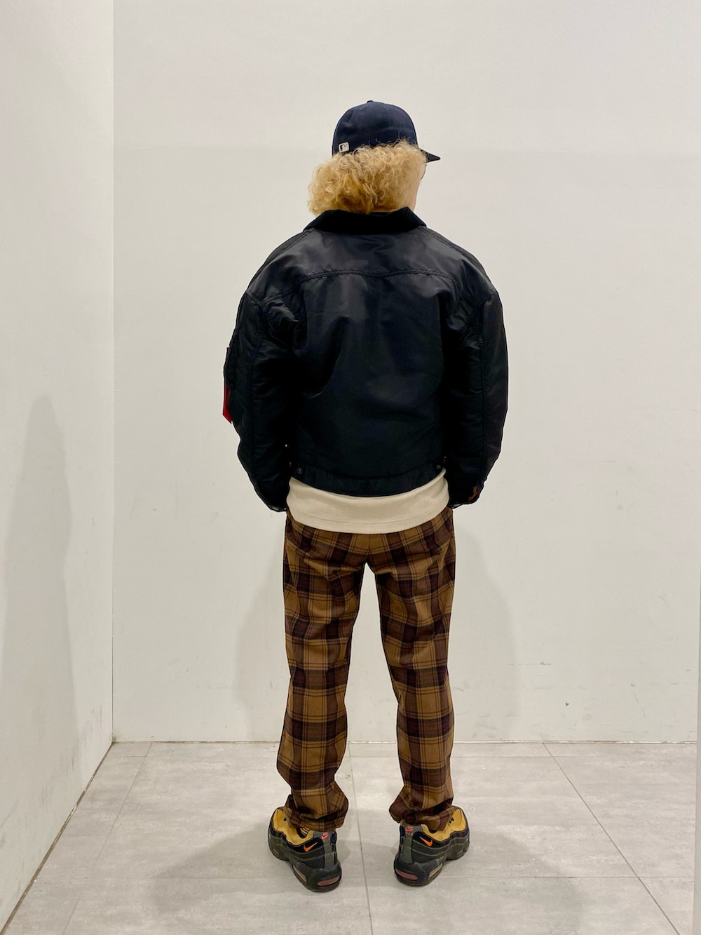 ブラック系のミリタリージャケット、ベージュ系のTシャツ/カットソー、ブラウン系のその他パンツを着用したメンズの冬コーディネートの2枚目の写真