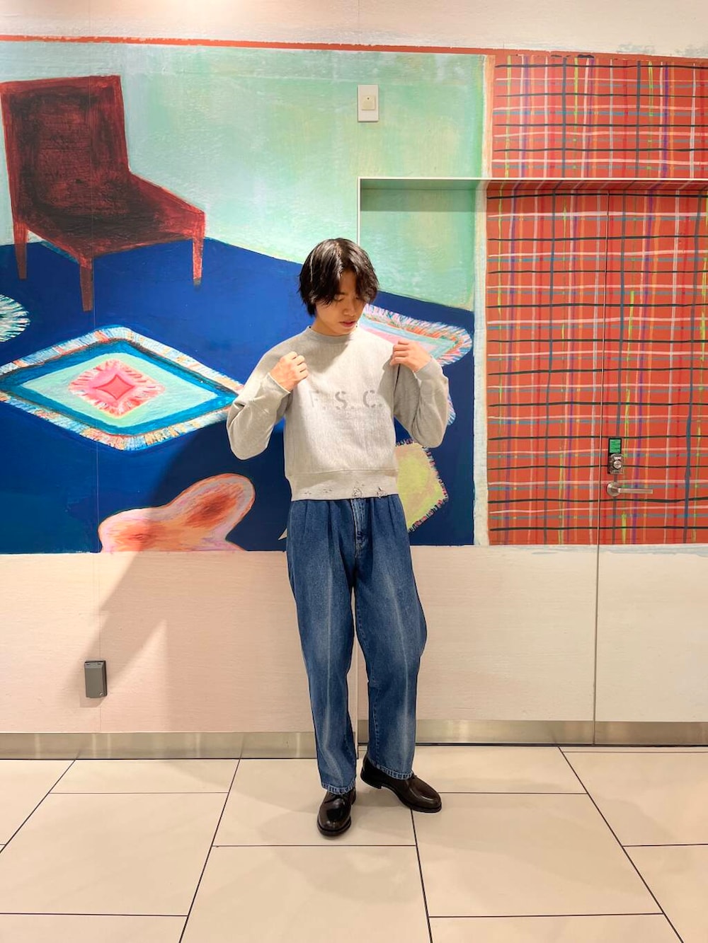 ブルー系のデニムパンツ、ブラック系のドレスシューズ、ブラック系のスウェットを着用したメンズの秋コーディネートの4枚目の写真