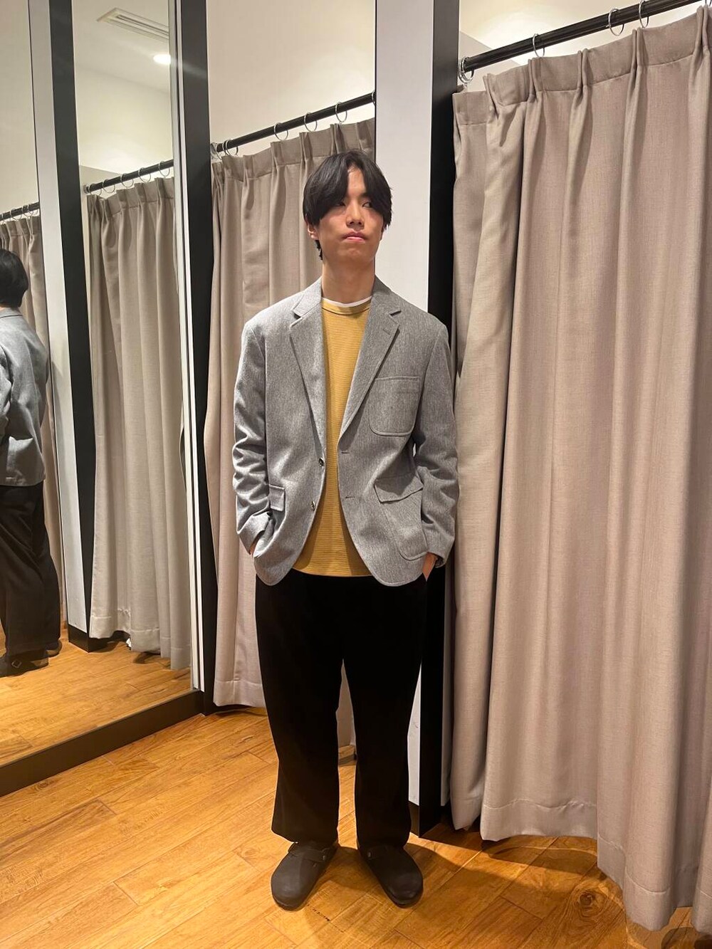 グレー系のその他アウター、ブラック系のサンダル、ブラウン系のTシャツ/カットソーを着用したメンズの冬コーディネートの6枚目の写真