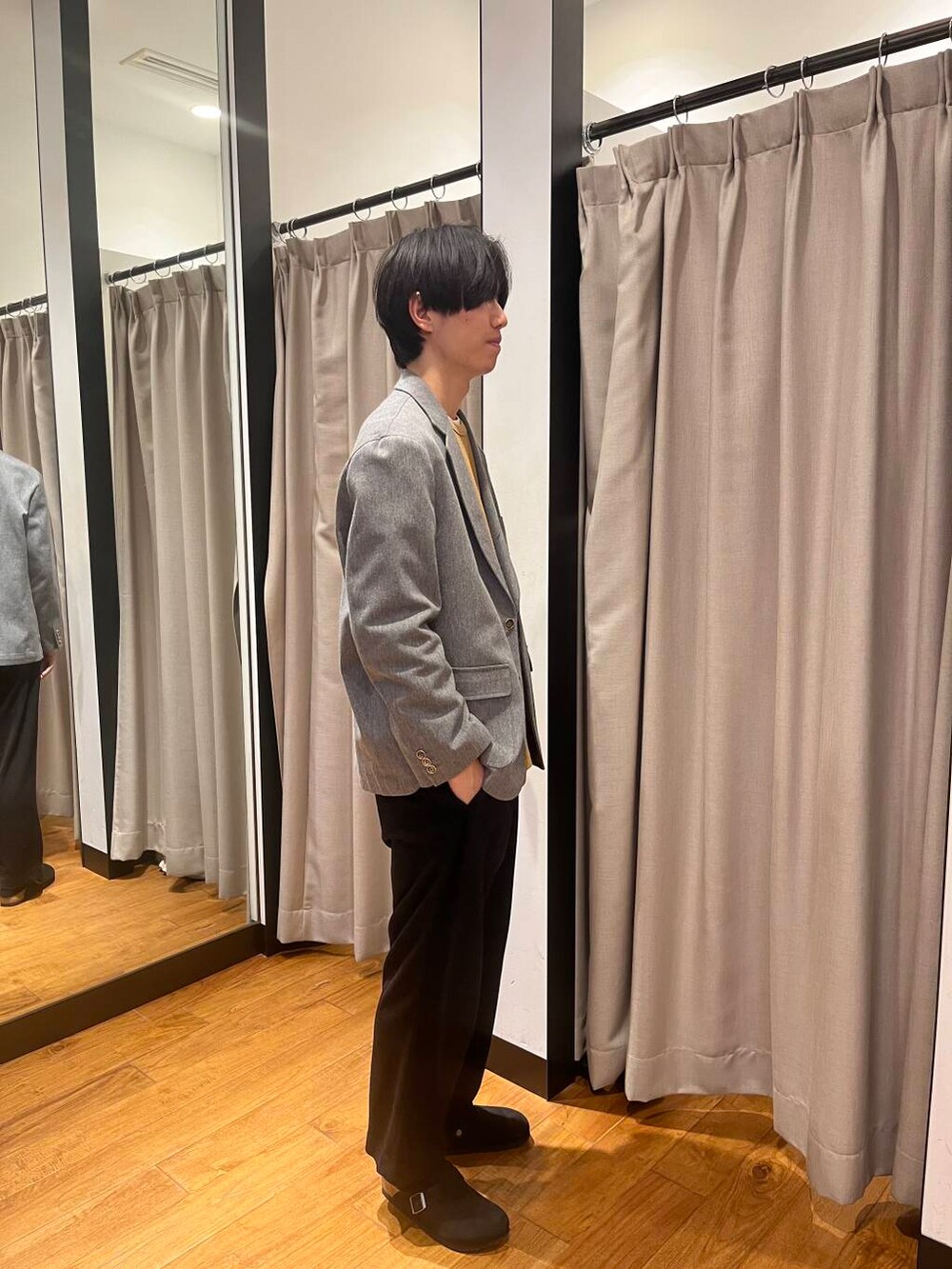 グレー系のその他アウター、ブラック系のサンダル、ブラウン系のTシャツ/カットソーを着用したメンズの冬コーディネートの3枚目の写真