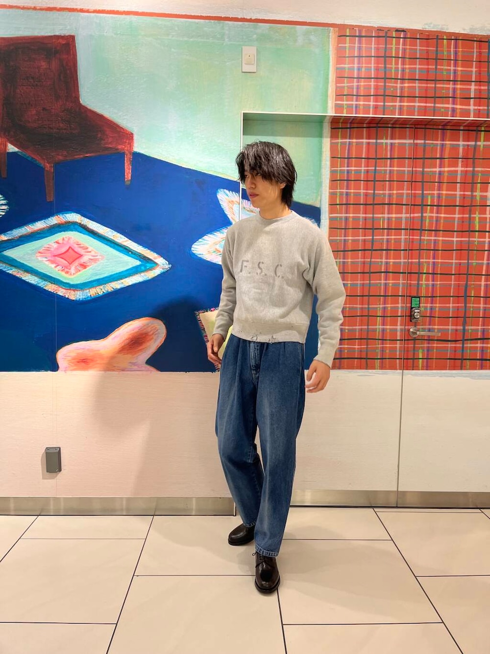 ブルー系のデニムパンツ、ブラック系のドレスシューズ、ブラック系のスウェットを着用したメンズの秋コーディネートの3枚目の写真