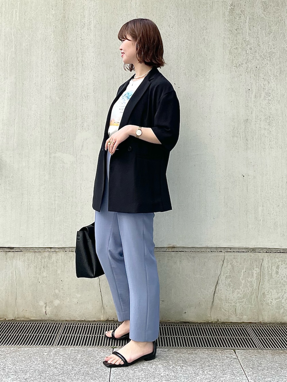 ブラック系のスーツジャケット、ホワイト系のTシャツ/カットソー、ブルー系のスーツパンツを着用したレディースの春コーディネートの2枚目の写真