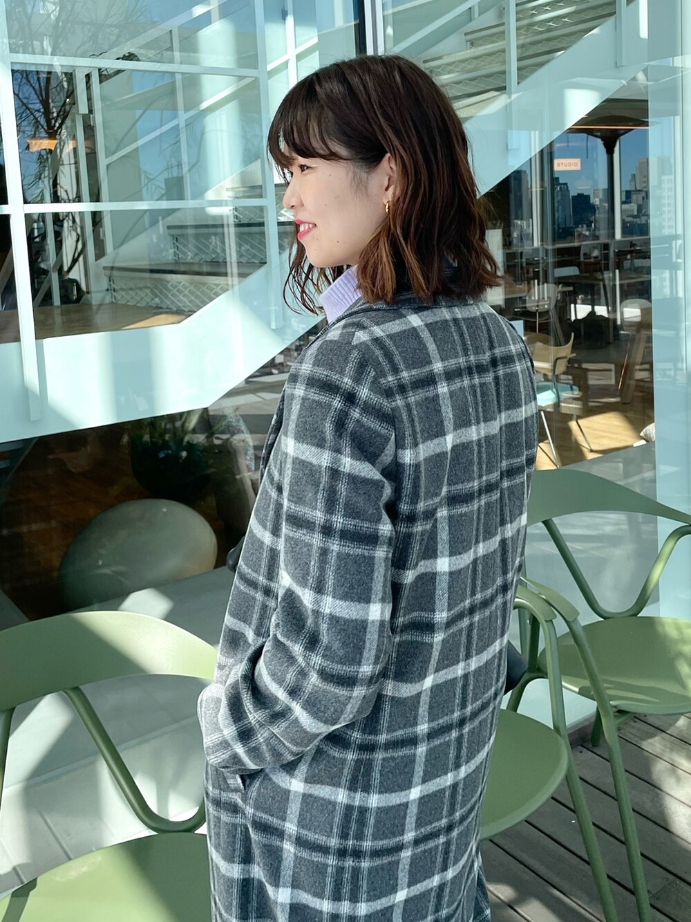 グレー系のチェスターコート、パープル系のニット/セーター、ブラック系のその他パンツを着用したレディースの冬コーディネートの5枚目の写真