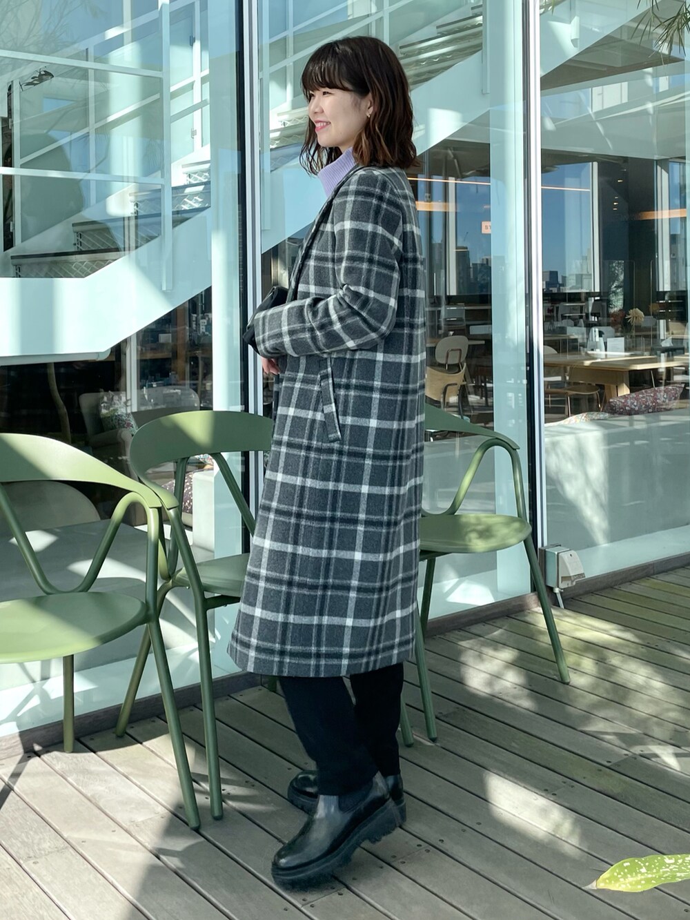 グレー系のチェスターコート、パープル系のニット/セーター、ブラック系のその他パンツを着用したレディースの冬コーディネートの2枚目の写真