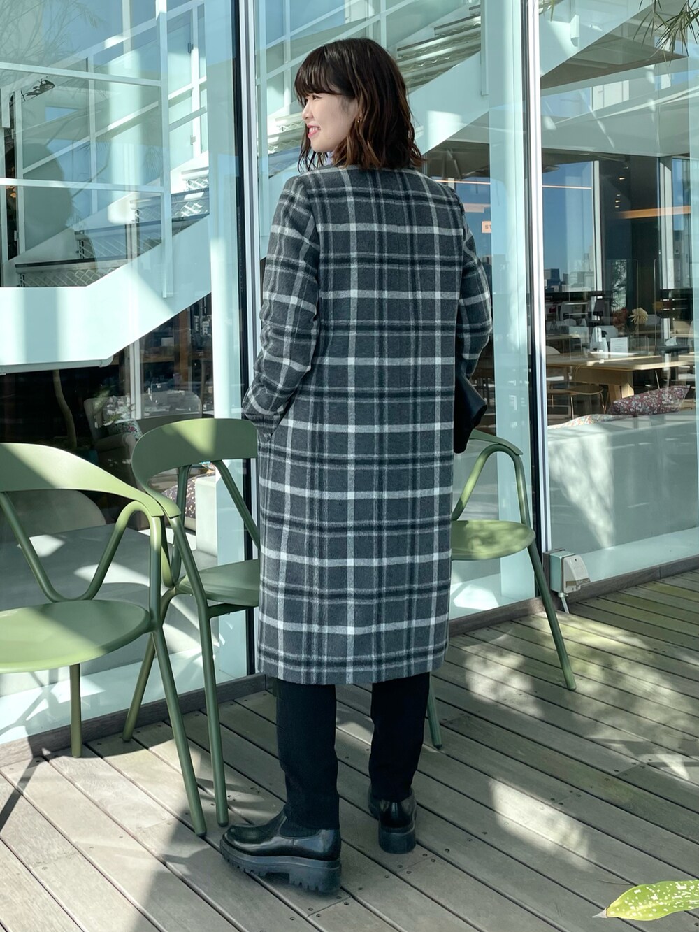 グレー系のチェスターコート、パープル系のニット/セーター、ブラック系のその他パンツを着用したレディースの冬コーディネートの3枚目の写真