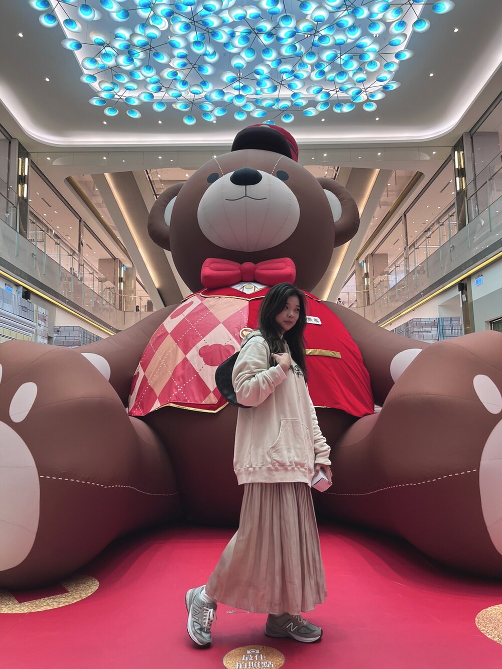 ベージュ系のトップス、ベージュ系のスカート、グレー系のスニーカーを着用したレディースの冬コーディネートの2枚目の写真