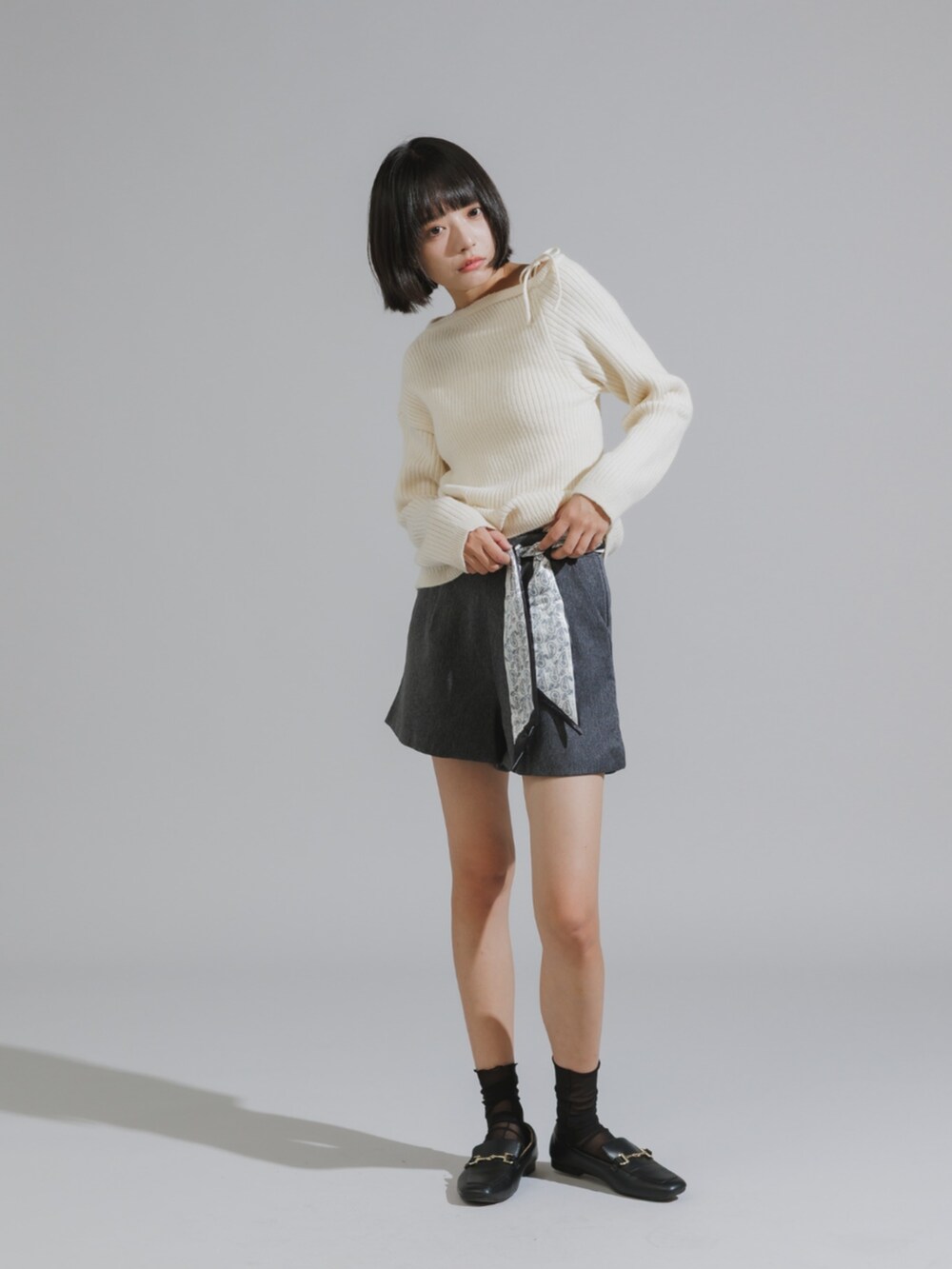 グレー系のその他パンツ、ホワイト系のニット/セーターを着用したレディースの秋コーディネートの2枚目の写真