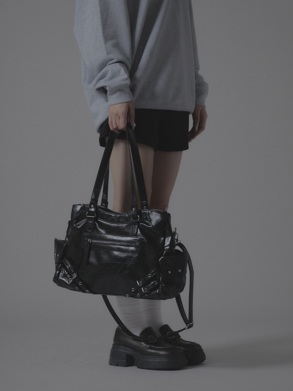 グレー系のスウェット、ブラック系のショルダーバッグを着用したレディースの秋コーディネートの4枚目の写真