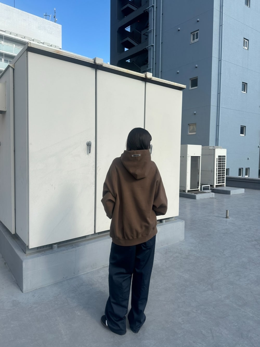 ブラウン系のパーカー、ブルー系のチノパンツを着用したレディースの春コーディネートの3枚目の写真