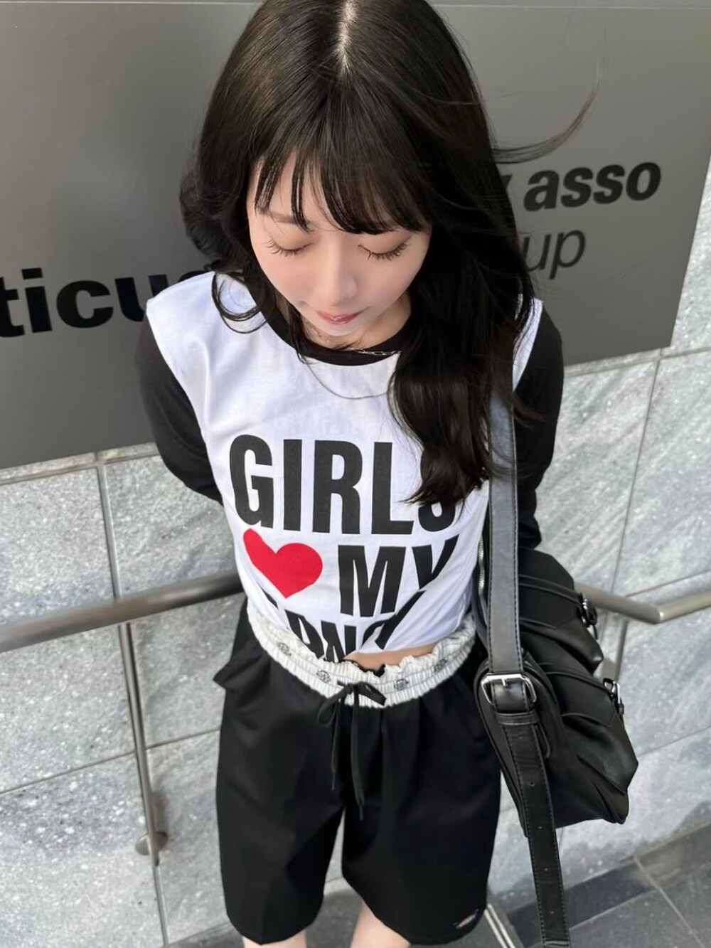 ブラック系のチノパンツ、ブラック系のショルダーバッグ、ブラック系のローファーを着用したレディースの夏コーディネートの3枚目の写真