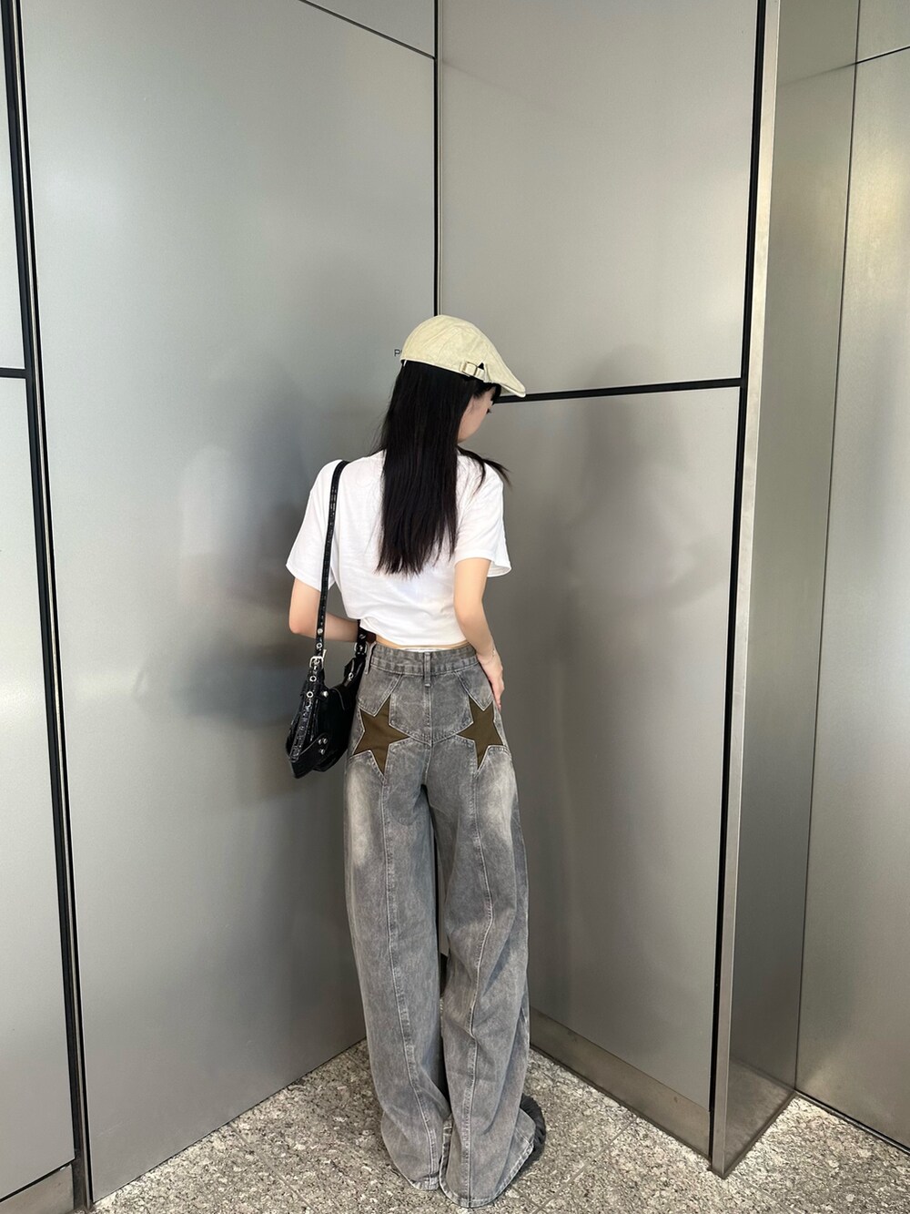 ホワイト系のTシャツ/カットソー、グリーン系のデニムパンツ、ブラック系のショルダーバッグを着用したレディースの夏コーディネートの2枚目の写真