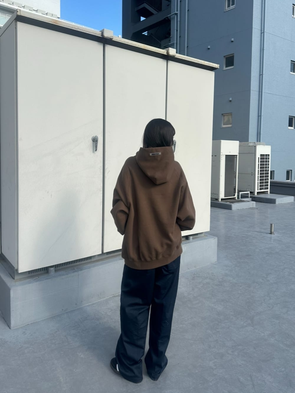 ブルー系のチノパンツ、ブラウン系のパーカーを着用したレディースの春コーディネートの3枚目の写真