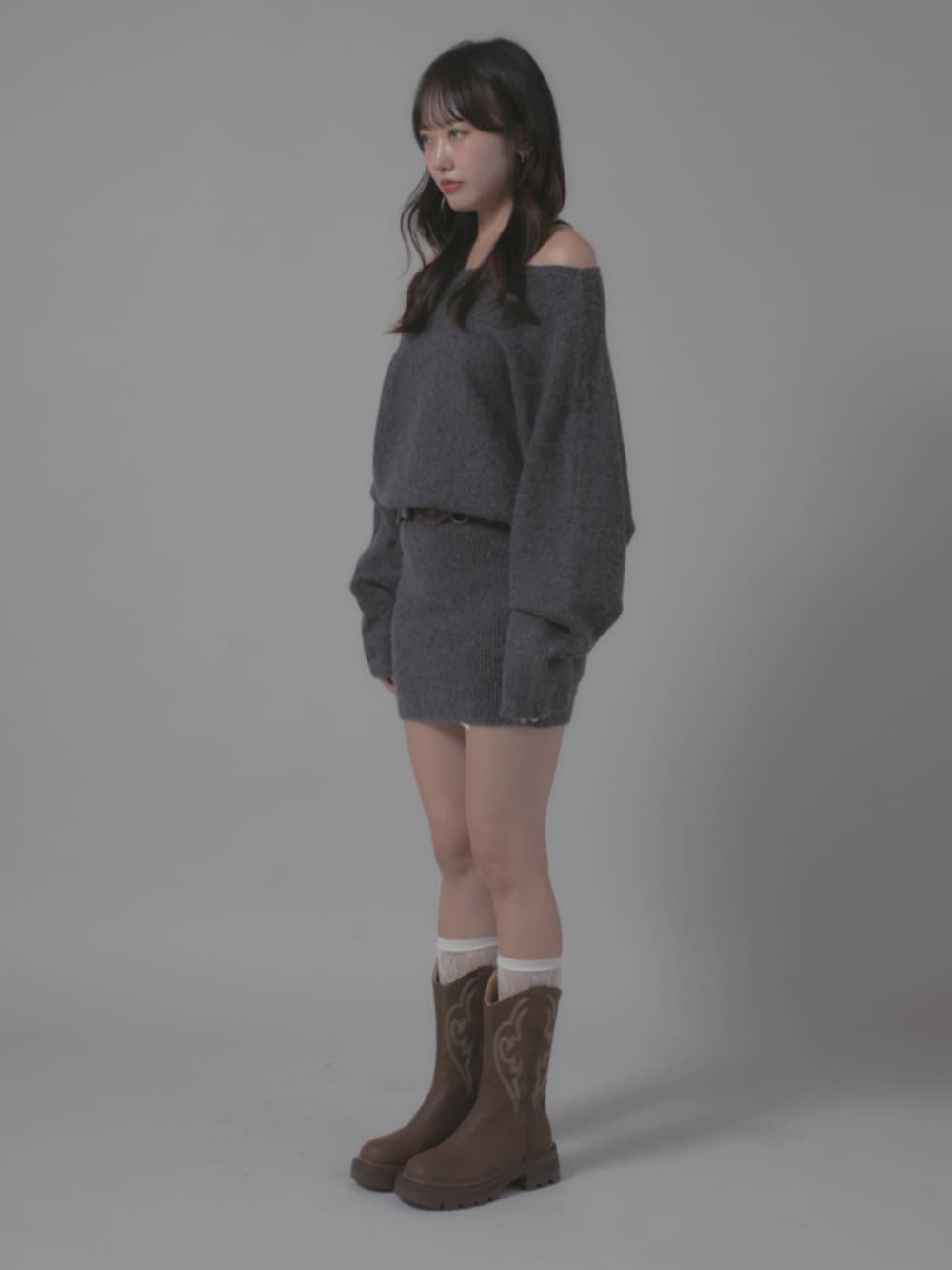 ブラウン系のブーツ、グレー系のワンピースを着用したレディースの秋コーディネートの2枚目の写真