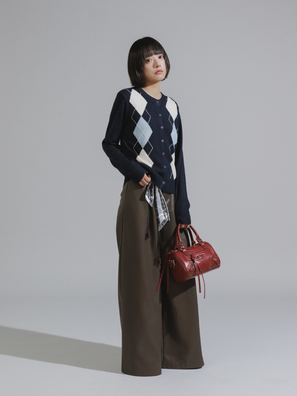 ブラック系のショルダーバッグ、ブラウン系のその他パンツ、ブルー系のカーディガン/ボレロを着用したレディースの秋コーディネートの2枚目の写真