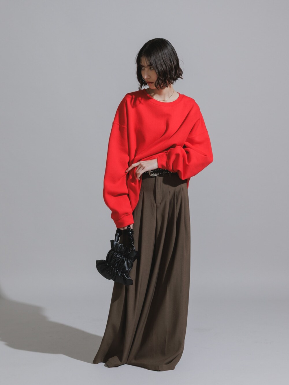 ブラウン系のスラックス、レッド系のTシャツ/カットソーを着用したレディースの秋コーディネートの2枚目の写真