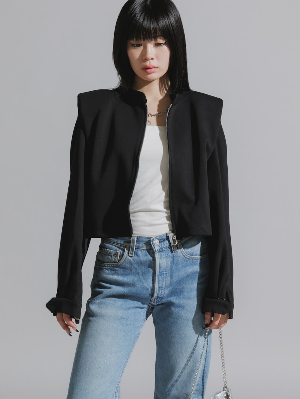 ブルー系のデニムパンツ、ブラック系のスウェットを着用したレディースの秋コーディネートの2枚目の写真