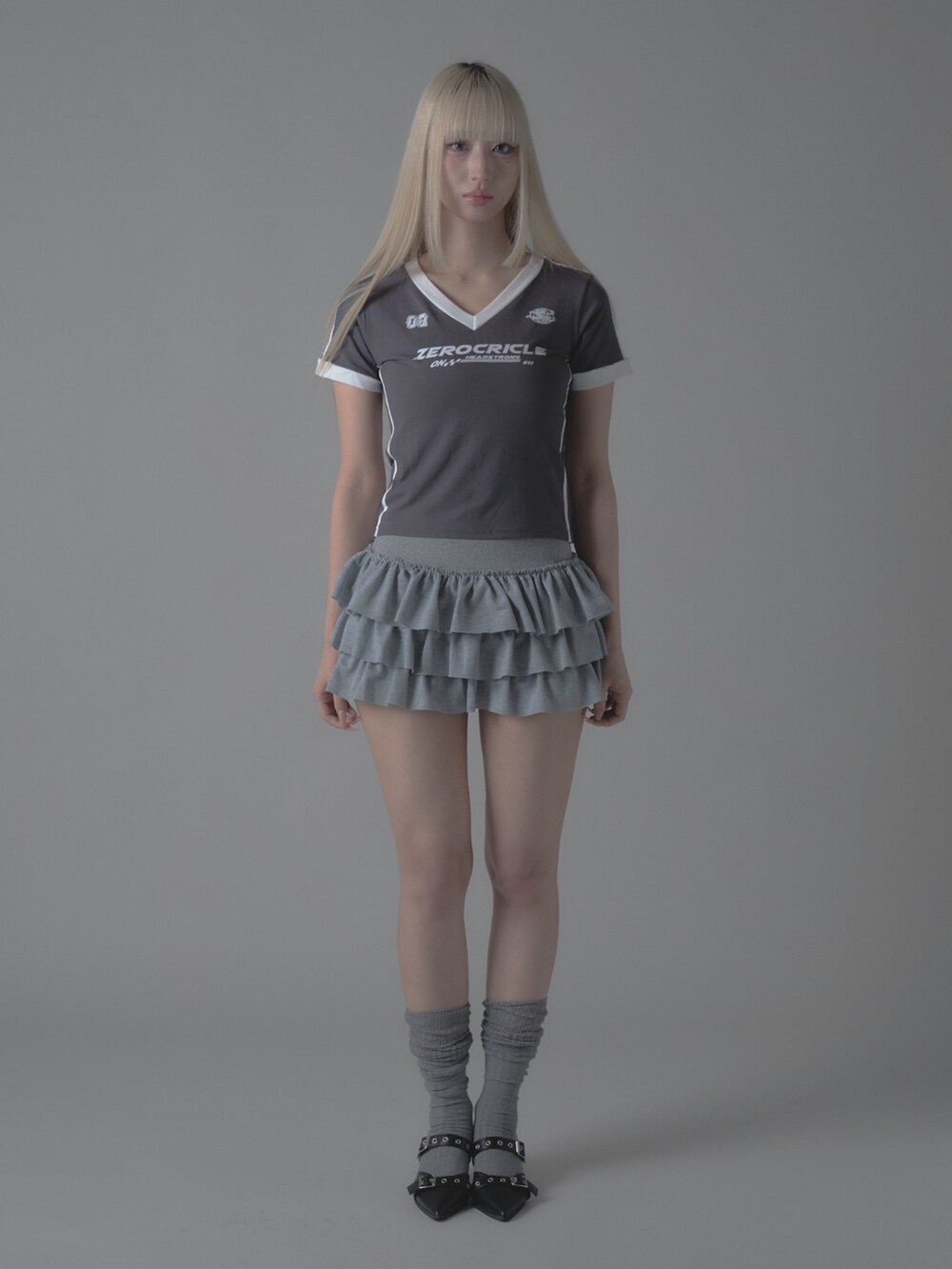 グレー系のTシャツ/カットソー、グレー系のスカート、シルバー系のパンプスを着用したレディースの秋コーディネートの2枚目の写真