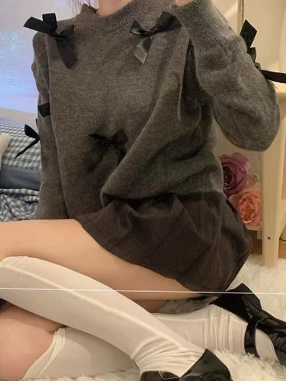 グレー系のニット/セーター、ブラック系のスカートを着用したレディースの秋コーディネートの2枚目の写真