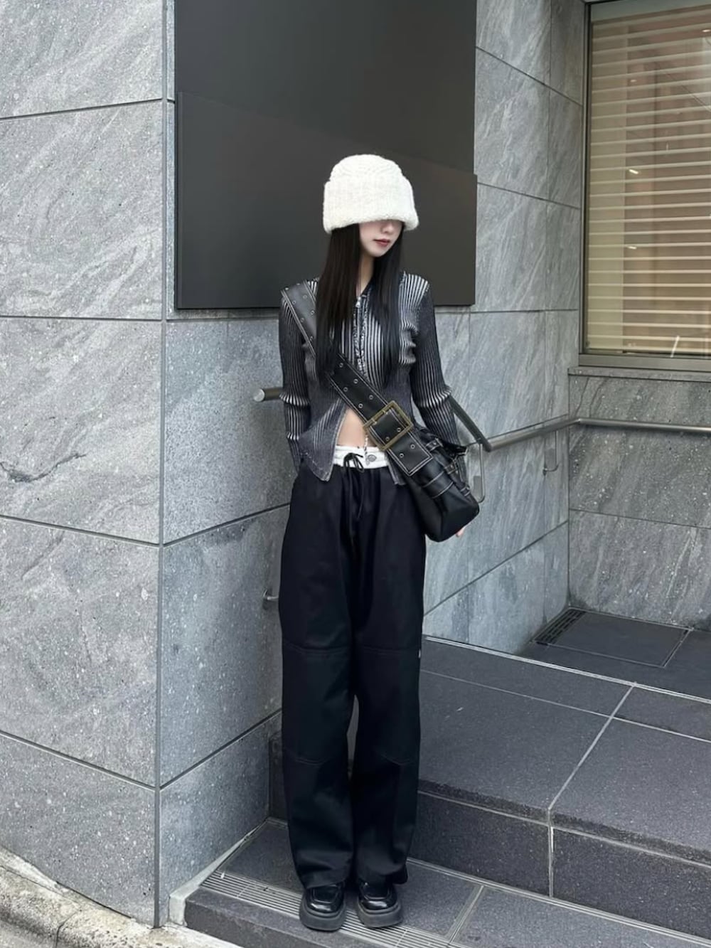 グレー系のチノパンツ、ブルー系のトップス、ブラック系のローファーを着用したレディースの秋コーディネートの2枚目の写真