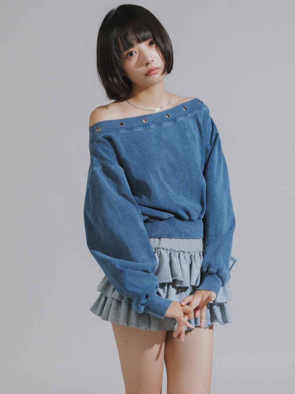 グレー系のスカート、ブルー系のスウェットを着用したレディースの秋コーディネートの2枚目の写真
