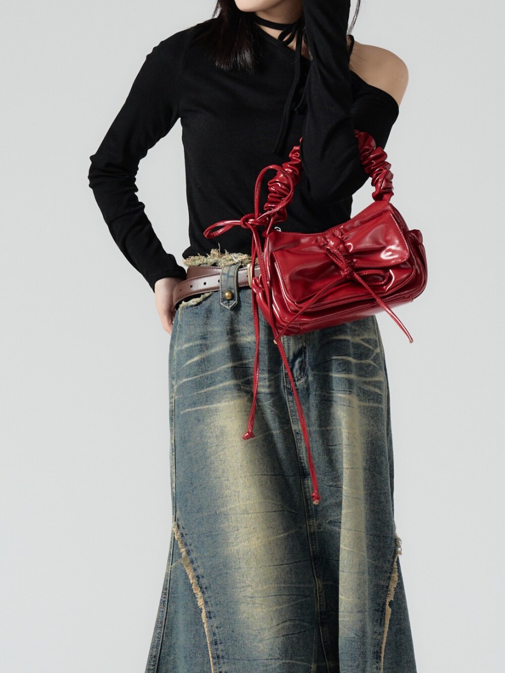 レッド系のハンドバッグを着用したレディースの秋コーディネートの2枚目の写真