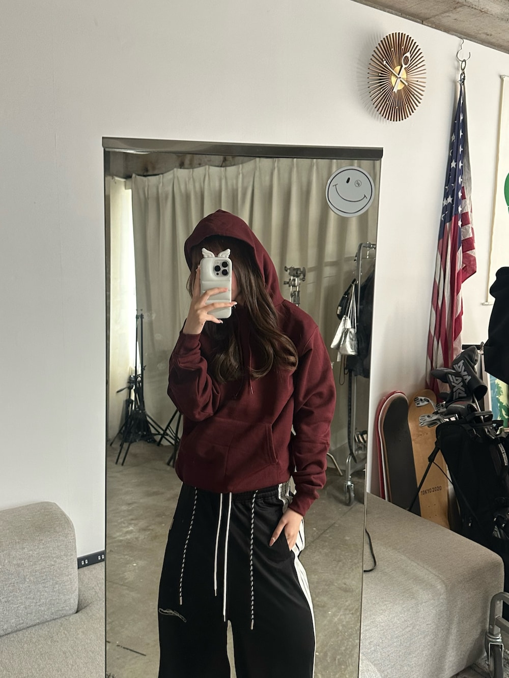 レッド系のパーカーを着用したレディースの春コーディネートの2枚目の写真