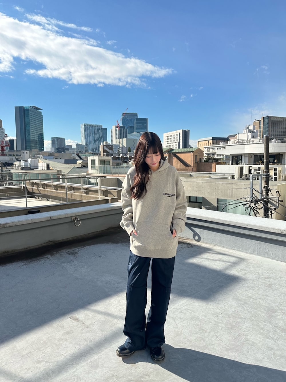 グレー系のパーカー、ブルー系のチノパンツを着用したレディースの春コーディネートの2枚目の写真