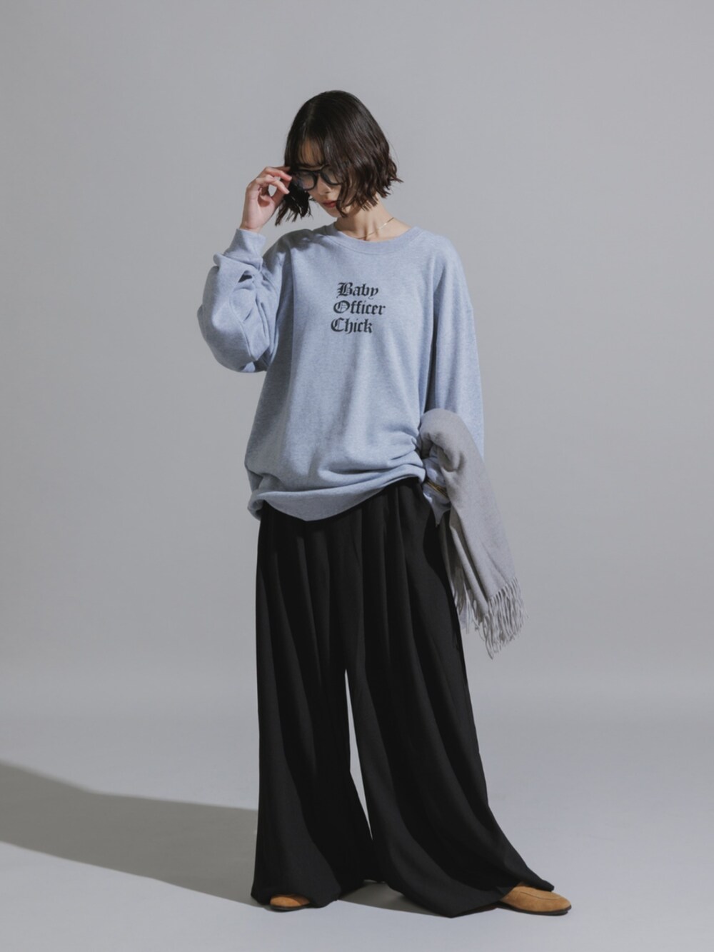 グレー系のスウェットを着用したレディースの秋コーディネートの2枚目の写真