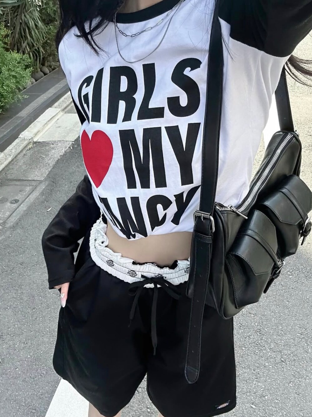 ブラック系のチノパンツ、ブラック系のショルダーバッグ、ブラック系のローファーを着用したレディースの夏コーディネートの2枚目の写真