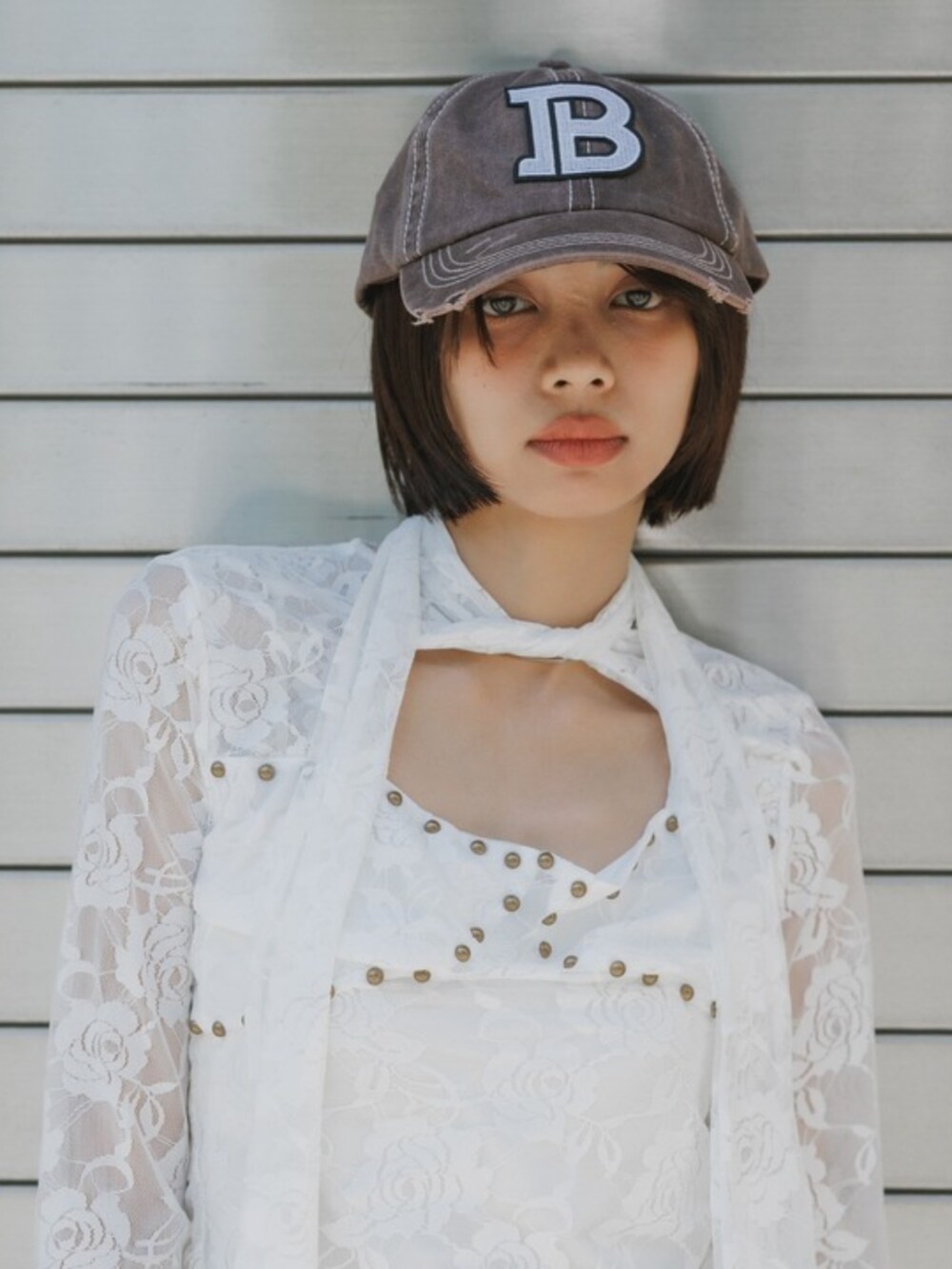 グリーン系のデニムパンツ、ホワイト系のTシャツ/カットソー、レッド系のキャップを着用したレディースの秋コーディネートの3枚目の写真