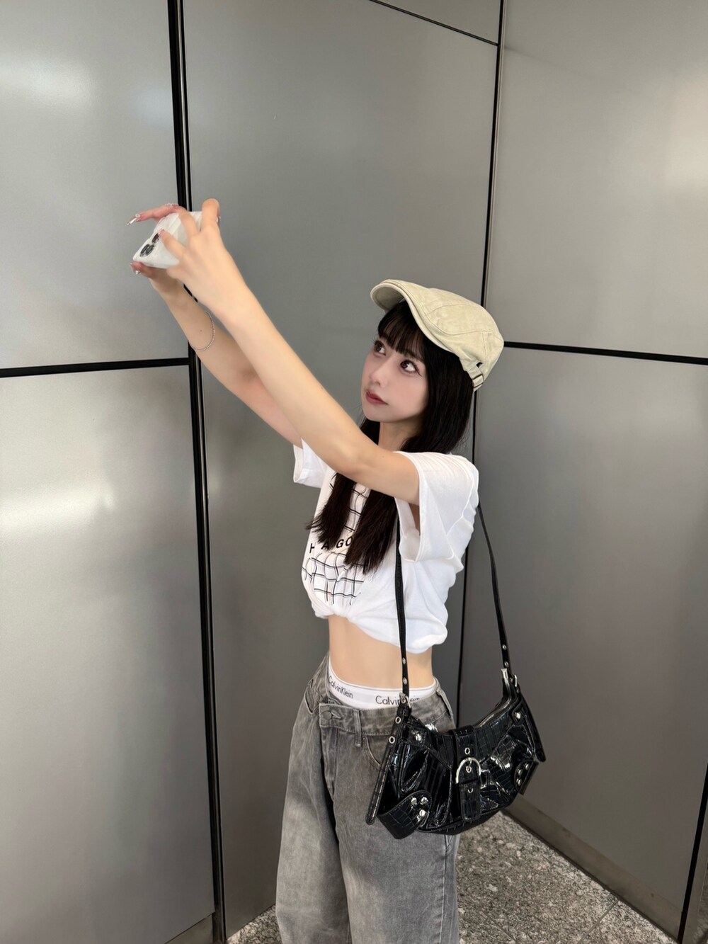 ホワイト系のTシャツ/カットソー、グリーン系のデニムパンツ、ブラック系のショルダーバッグを着用したレディースの夏コーディネートの3枚目の写真