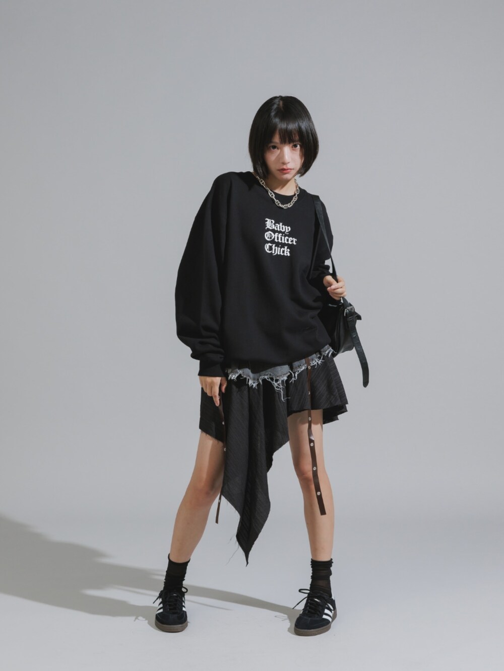 ブラック系のスウェット、ブルー系のデニムスカート、ブラック系のスニーカーを着用したレディースの秋コーディネートの2枚目の写真