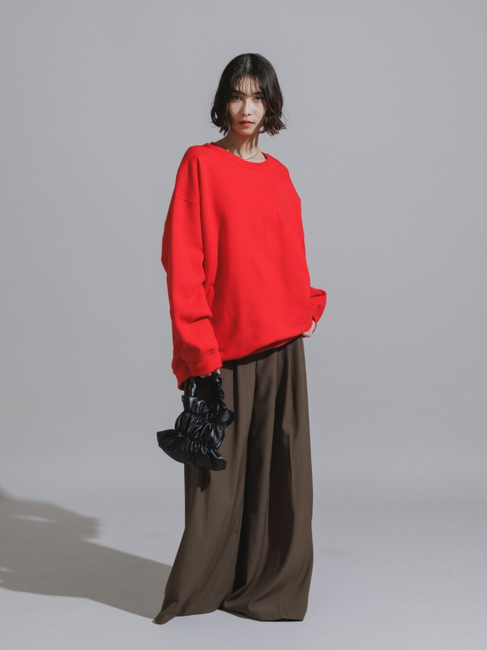 ブラウン系のスラックス、レッド系のTシャツ/カットソーを着用したレディースの秋コーディネートの3枚目の写真