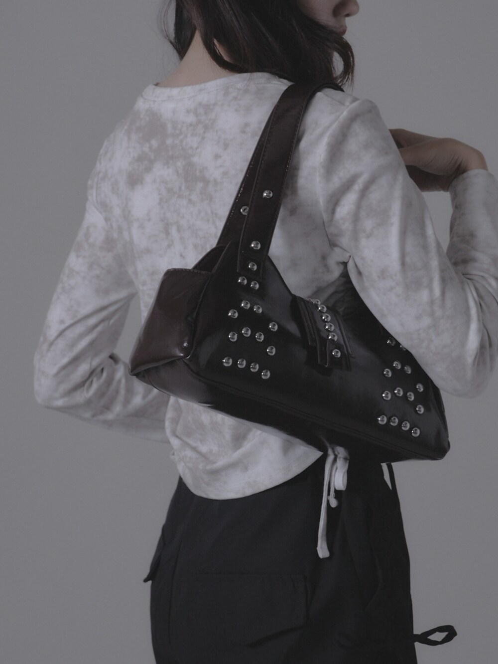 ブラウン系のショルダーバッグを着用したレディースの秋コーディネートの2枚目の写真