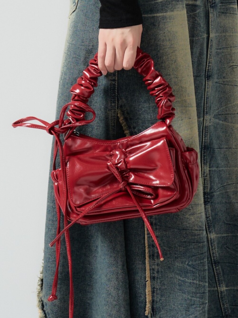 レッド系のハンドバッグを着用したレディースの秋コーディネートの3枚目の写真